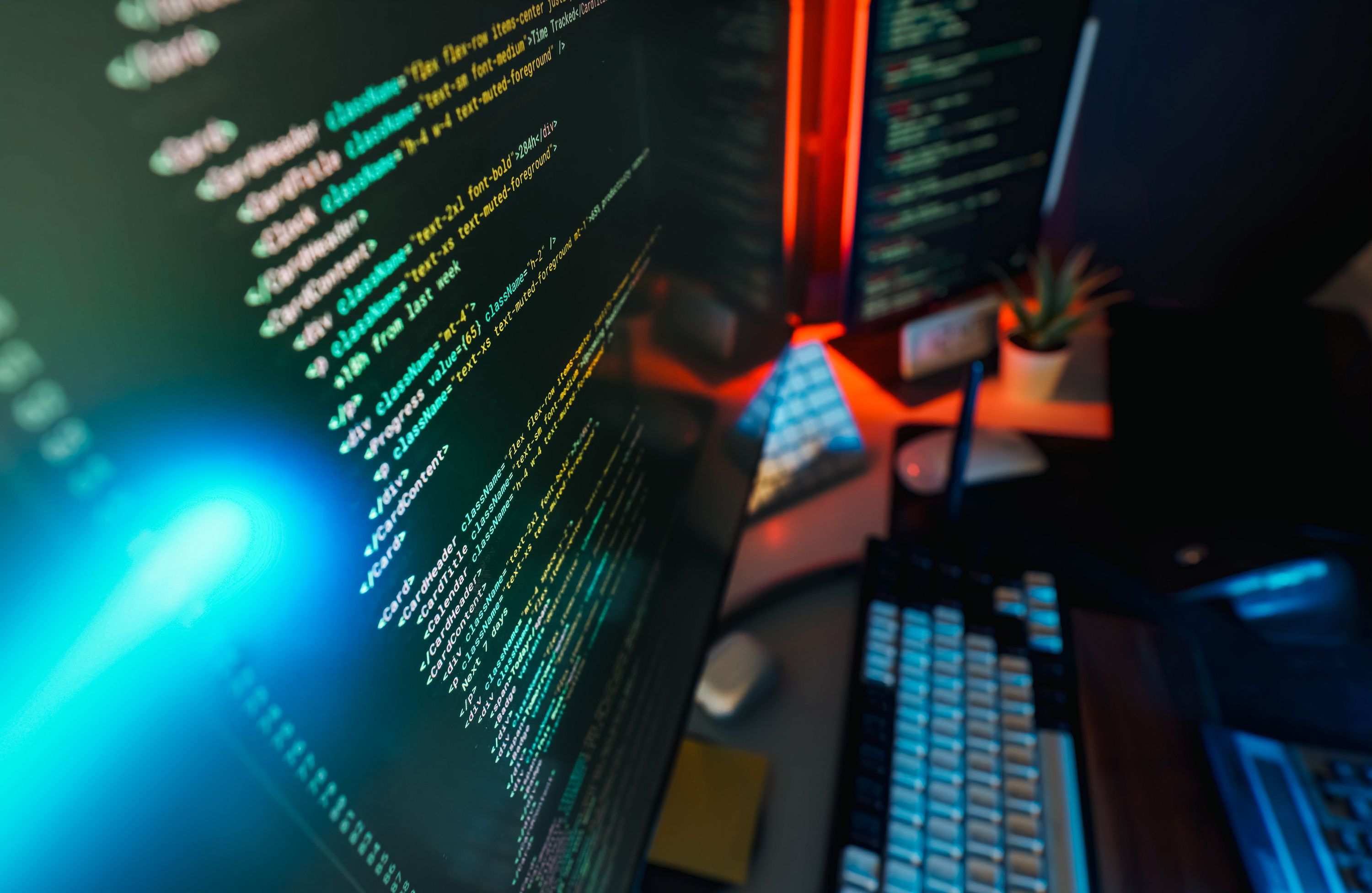 Computer monitor showing software development work at a desk, workspace with coding screens and keyboard
