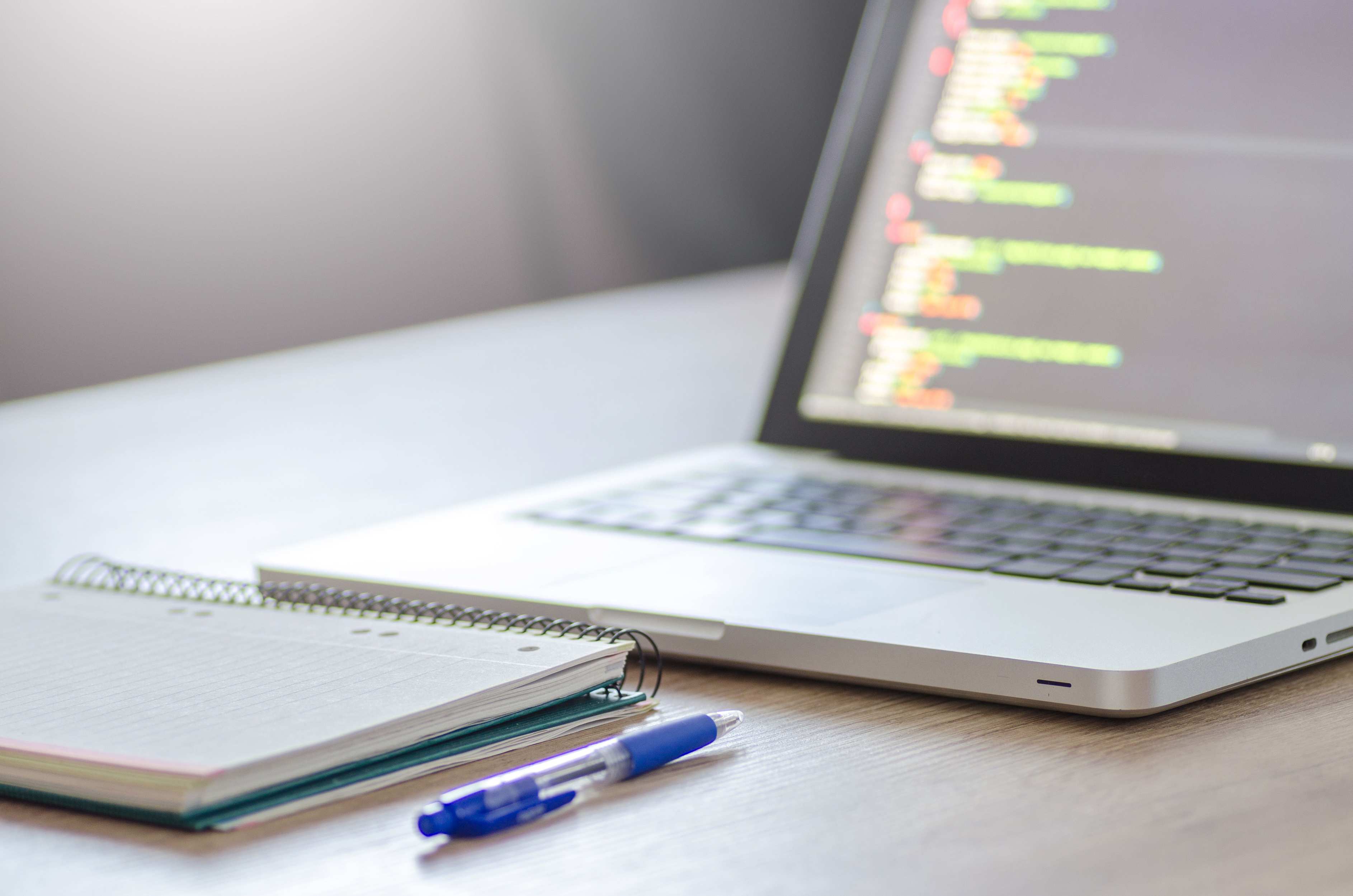 Laptop on a desk in a software development workspace with coding setup